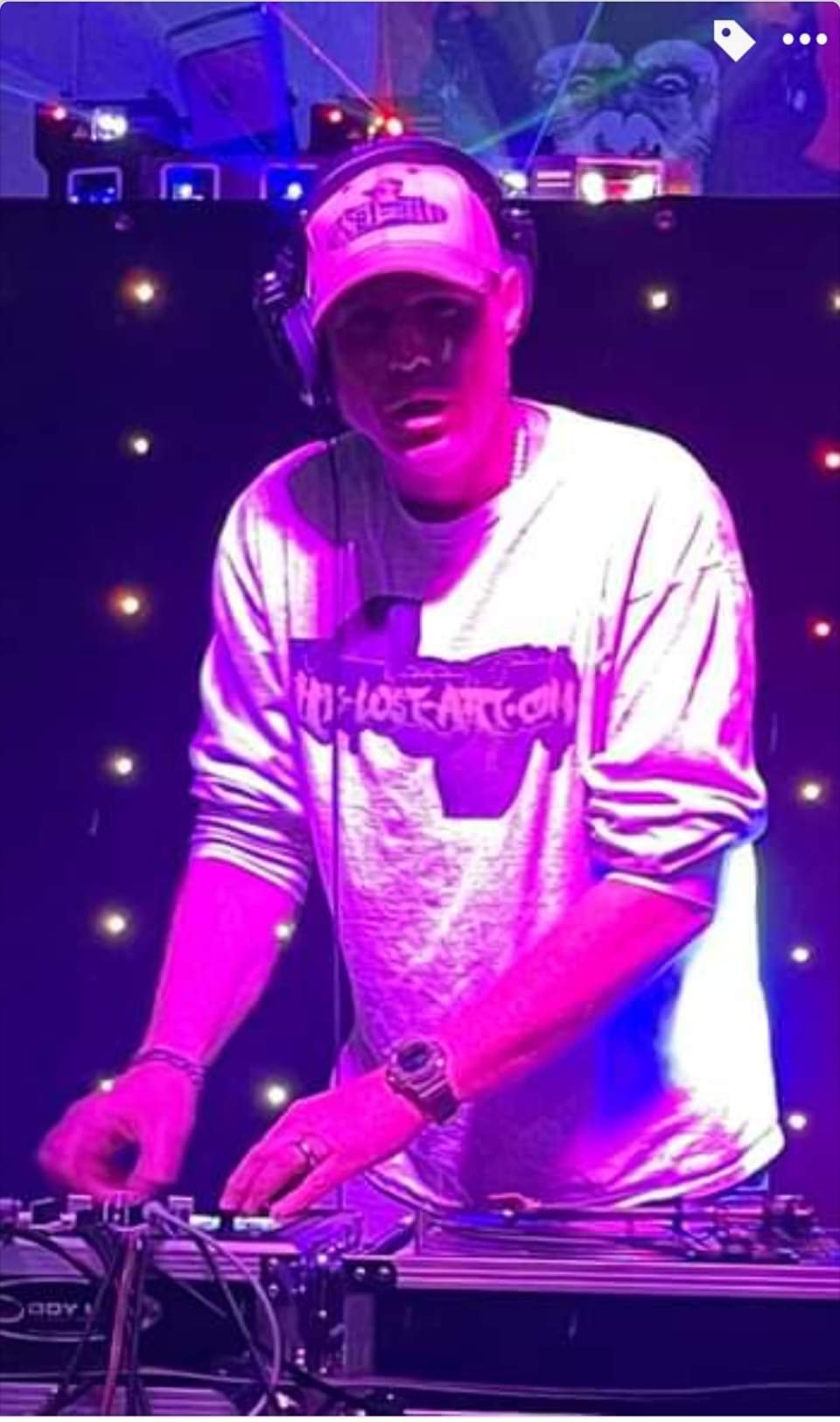DJ Natural Nate® on stage in The-Lost-Art.com shirt under purple and pink stage lighting